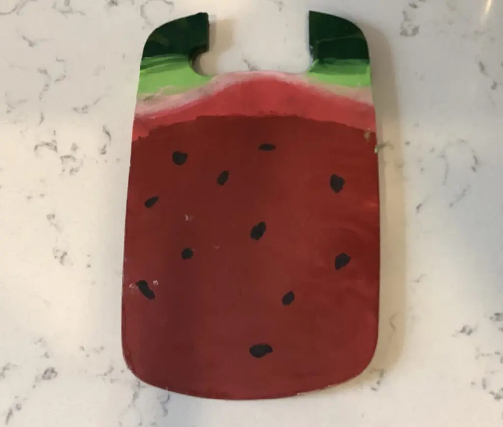 Broken cutting board painted as a watermelon.