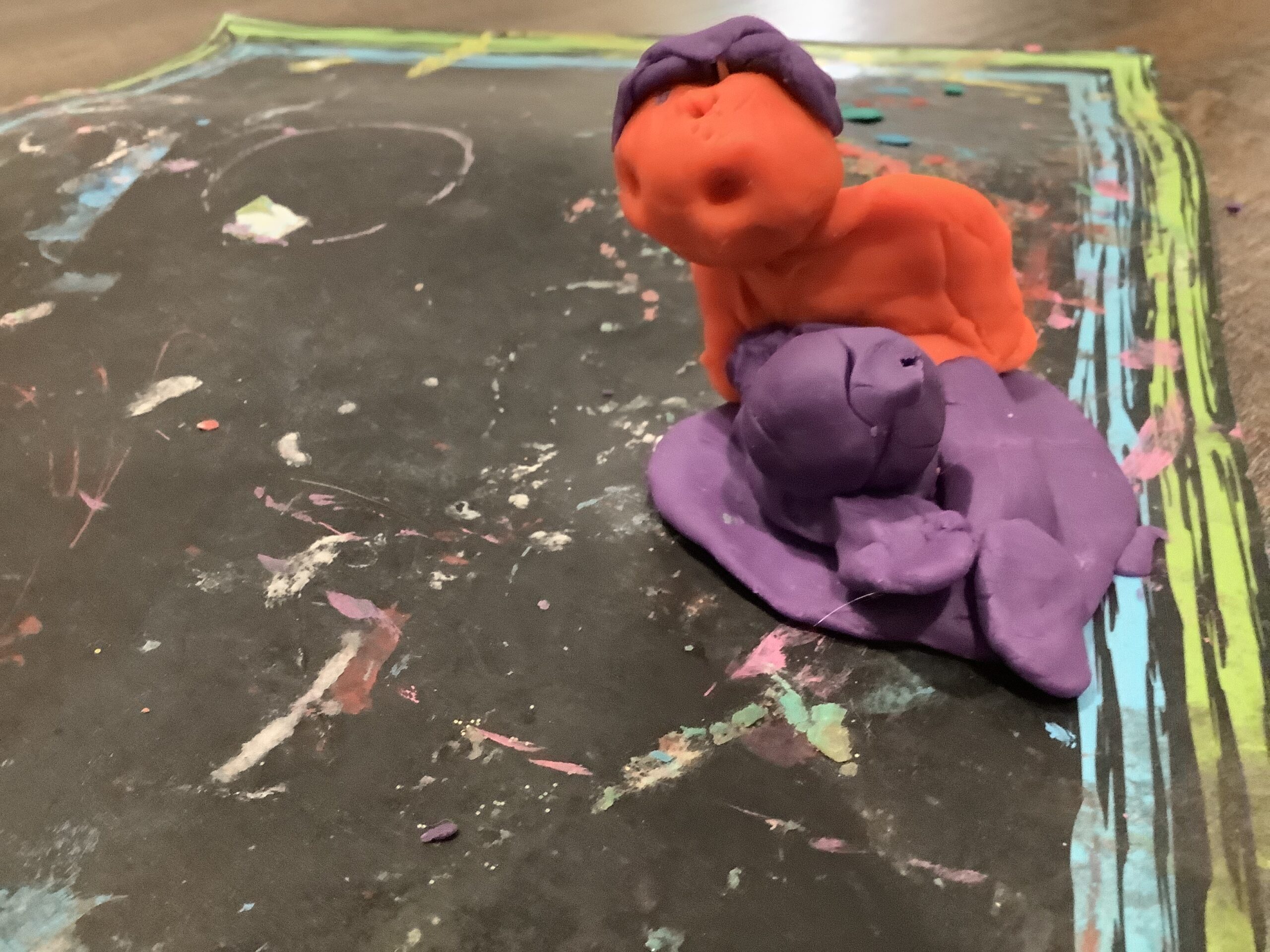 A play dough sculpture . The colors are orange and purple.