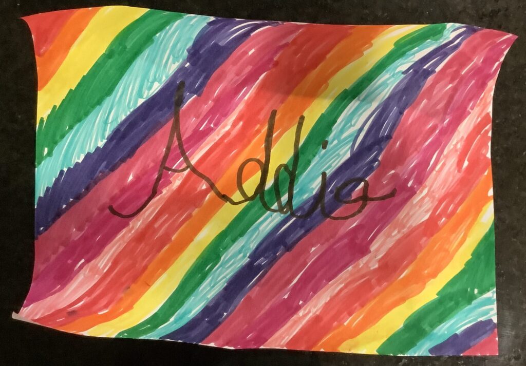 Rainbow stripes with Addie written in cursive in black marker.