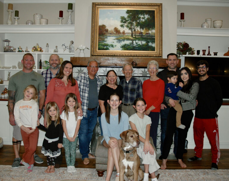 16 people in my family posing for a picture.