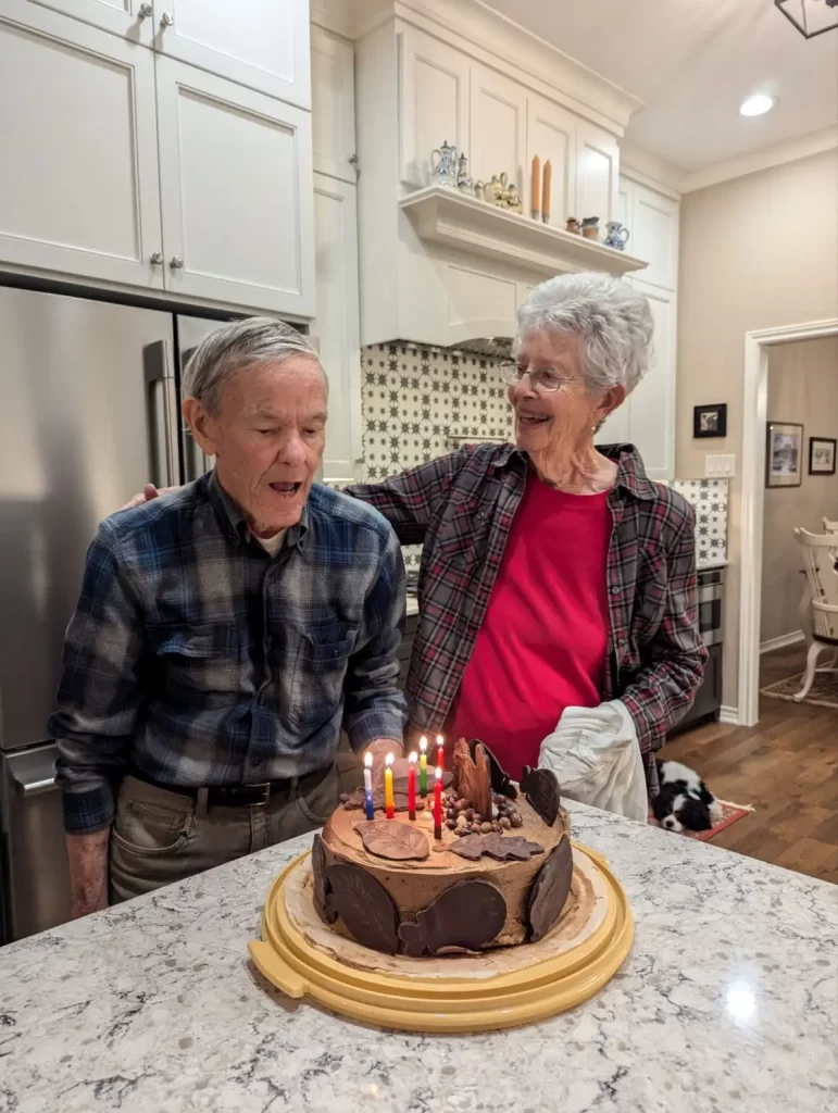 Uncle Chuck and Aunt Sally by a birthday cake.