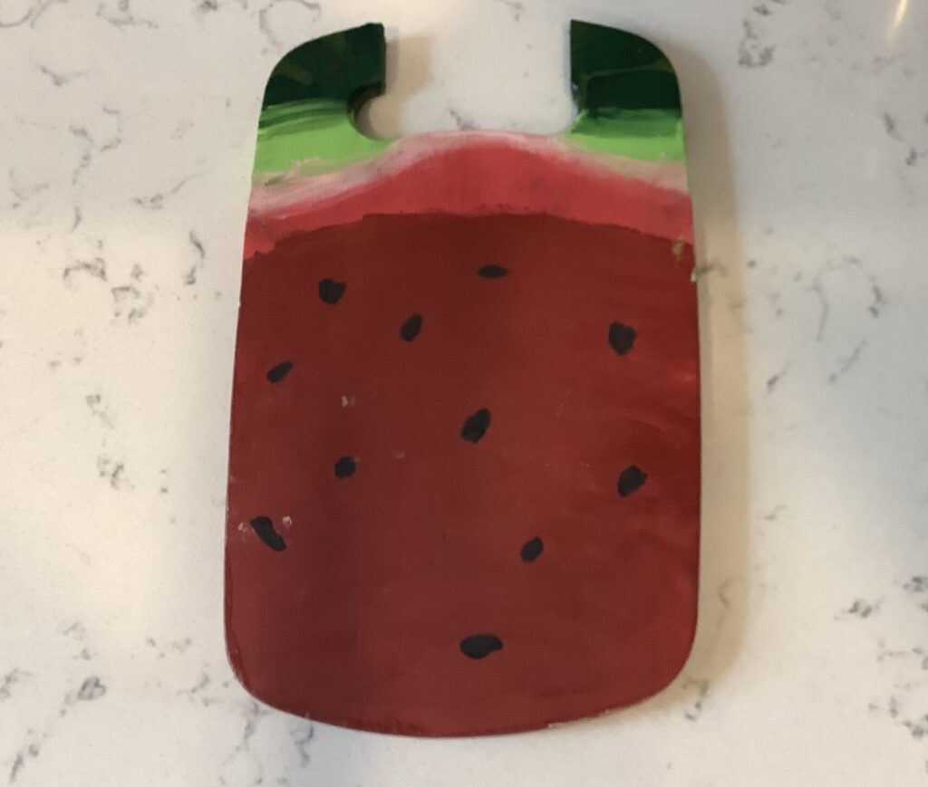 Broken cutting board painted as a watermelon.